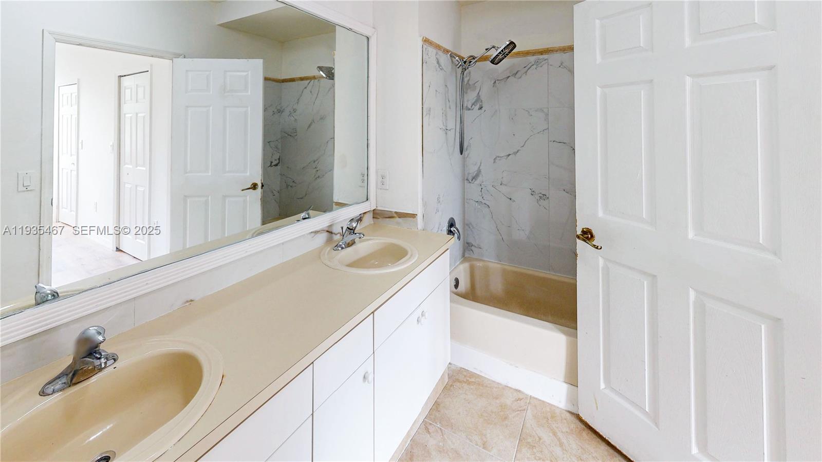 27345 Southwest 138th Court Homestead, FL 33032 - Photo 35 of 75 a bathroom with a granite countertop sink a mirror a bathtub and shower