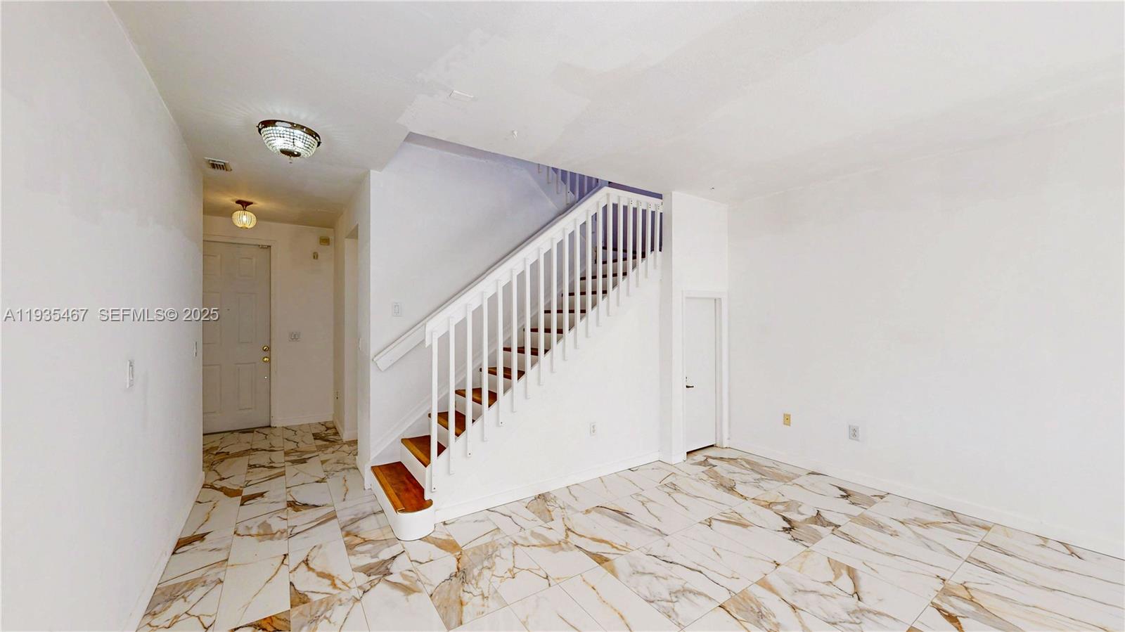 27345 Southwest 138th Court Homestead, FL 33032 - Photo 9 of 75 a view of a hallway to a bedroom with wooden floor and stairs