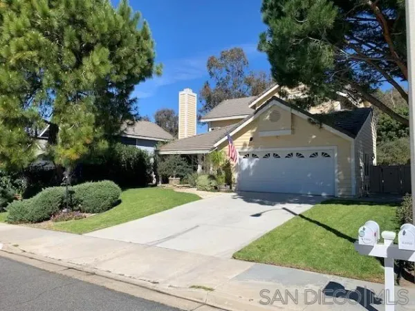 front view of house with a yard and potted plants