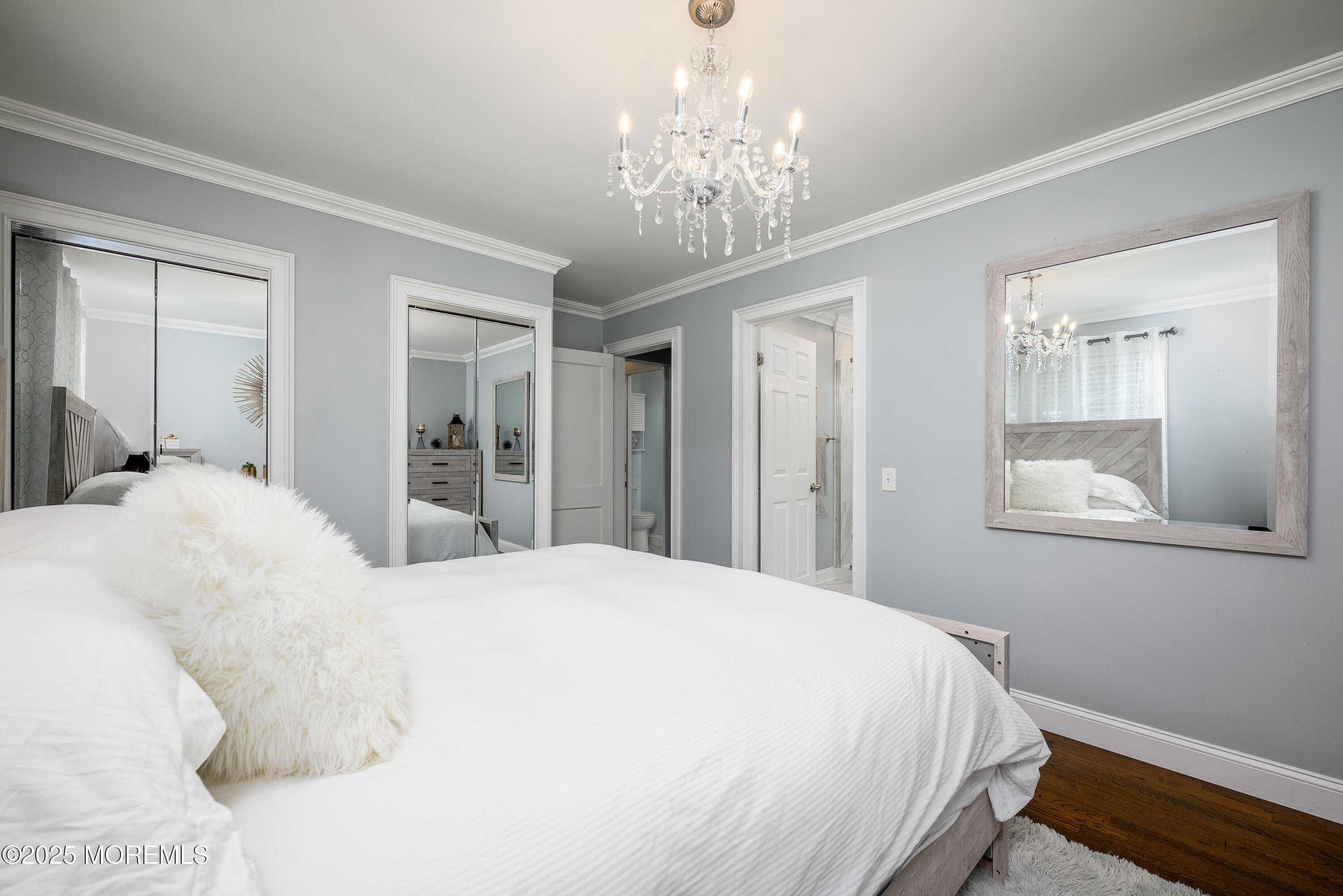 3213 Ridgewood Road Allenwood, NJ 08720 - Photo 27 of 42 a bedroom with a large bed and a chandelier