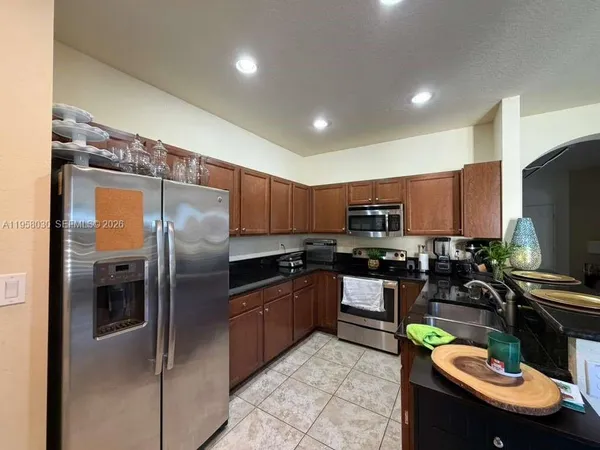 a kitchen with kitchen island granite countertop stainless steel appliances and a refrigerator
