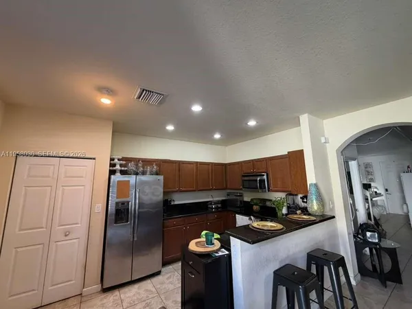 a kitchen with stainless steel appliances granite countertop a refrigerator and a stove
