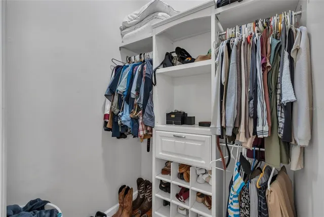 a view of walk in closet with clothes and shoes