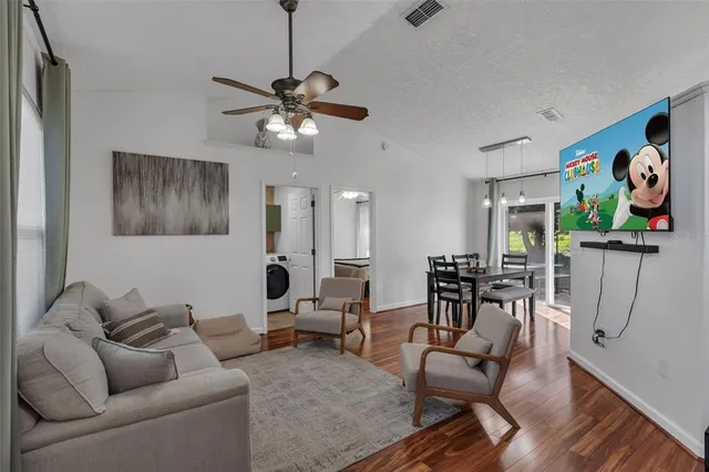 a living room with furniture a desk and chair with wooden floor