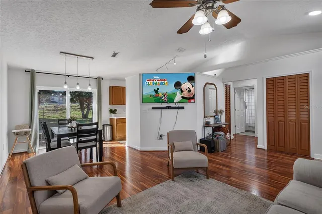 a living room with furniture kitchen view and a window
