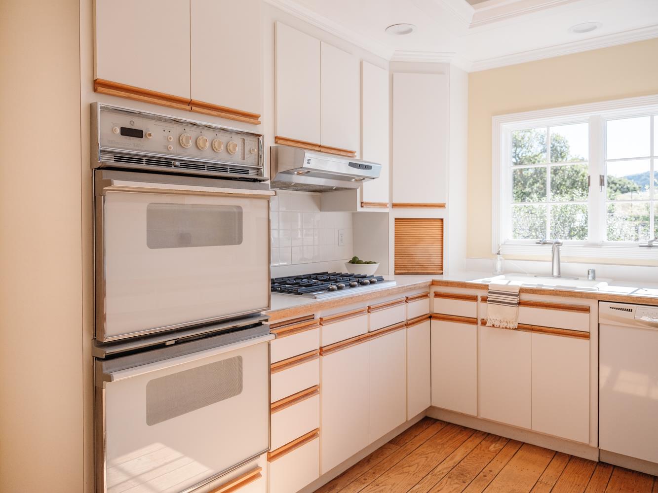 802 Covington Road Belmont, CA 94002 - Photo 9 of 28 a kitchen with a stove cabinets and wooden floor