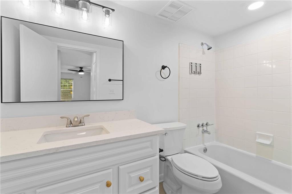 1150 Collier Road Northwest, Unit A1 Atlanta, GA 30318 - Photo 12 of 27 a bathroom with a toilet a sink a mirror and vanity