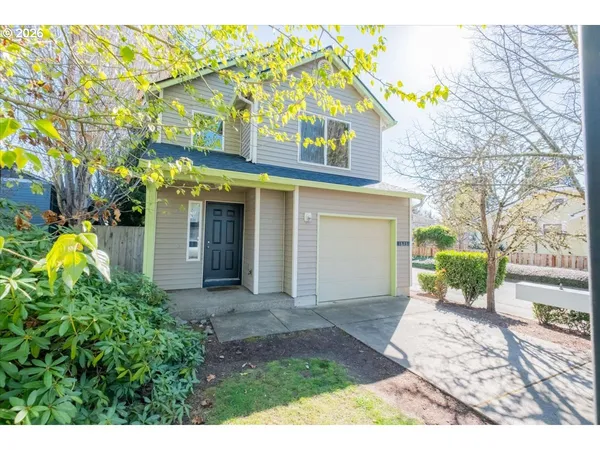 a view of a white house with large windows and plants