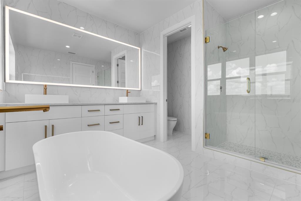772 Gran Kaymen Way Apollo Beach, FL 33572 - Photo 22 of 35 a bathroom with a sink a toilet and shower