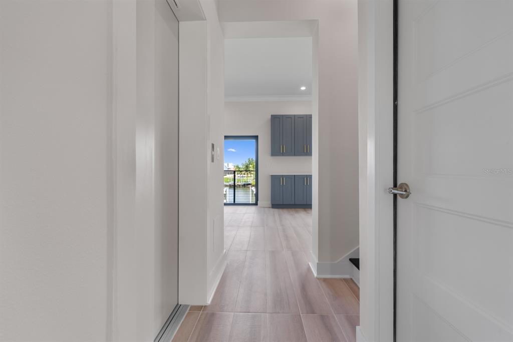772 Gran Kaymen Way Apollo Beach, FL 33572 - Photo 6 of 35 a view of a hallway with wooden floor and a bathroom