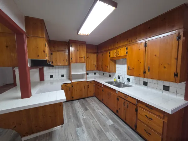 a kitchen with stainless steel appliances sink cabinets and wooden floor