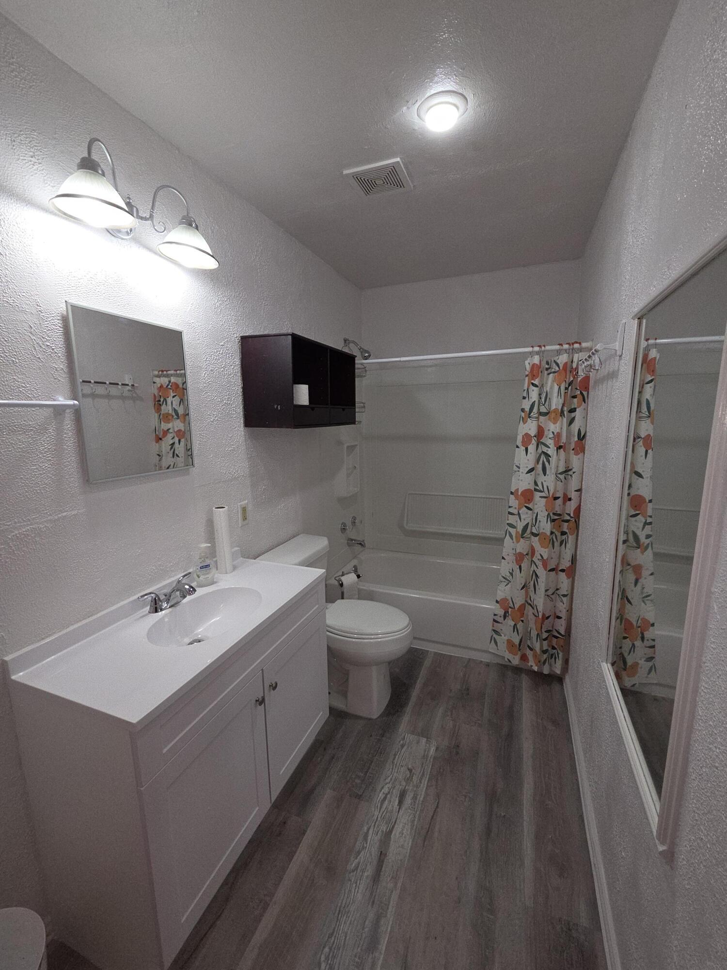 600 Vernon Plainview, TX 79072 - Photo 10 of 30 a bathroom with a sink a toilet and a large mirror