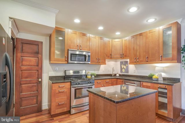 a dining room with stainless steel appliances granite countertop furniture and chandelier