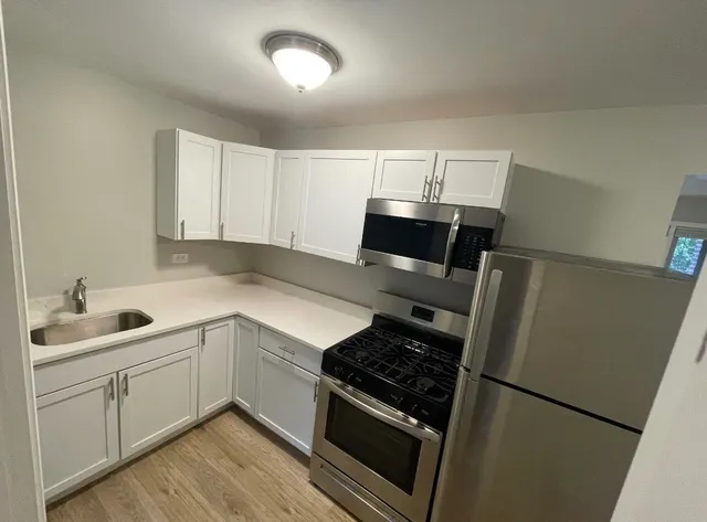 a kitchen with a sink and white stainless steel appliances