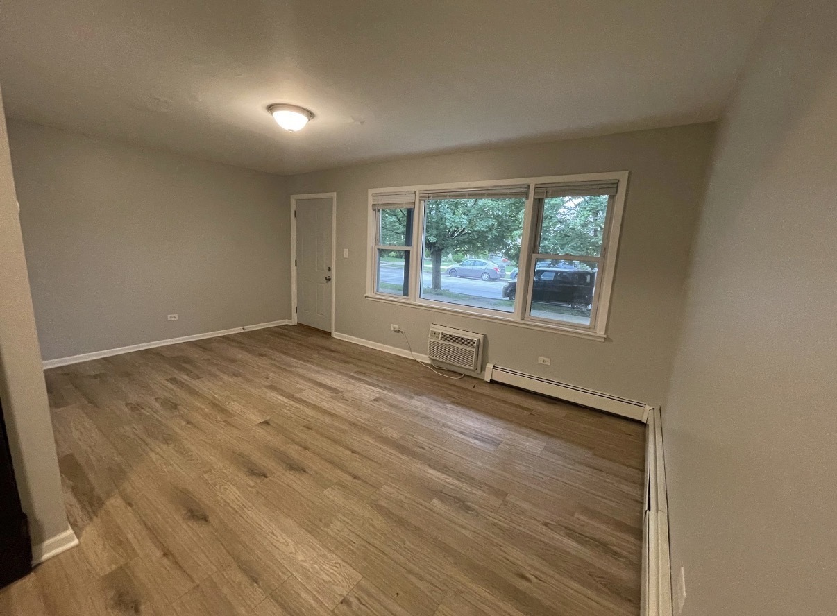 5331 South Kilbourn Avenue, Unit 3 Chicago, IL 60632 - Photo 4 of 7 an empty room with wooden floor and windows