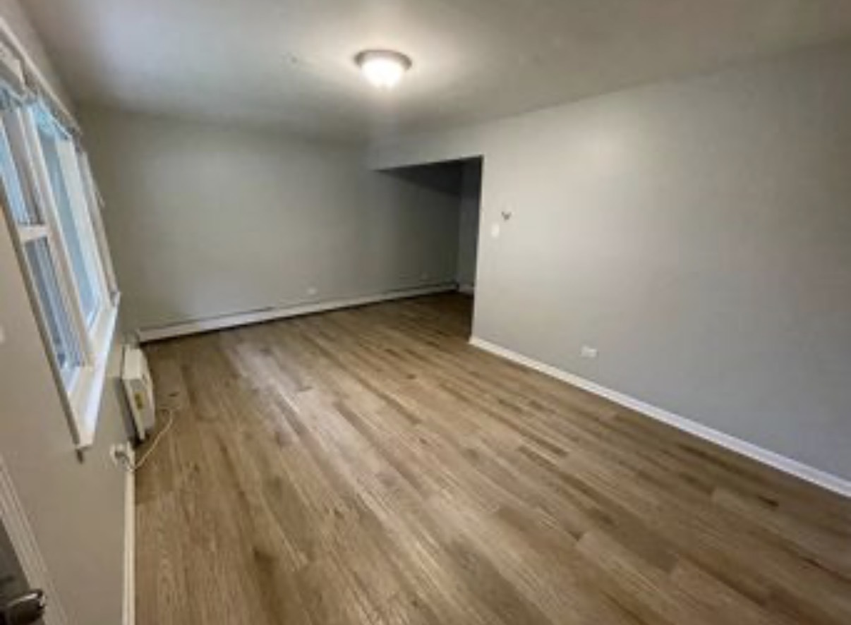 5331 South Kilbourn Avenue, Unit 3 Chicago, IL 60632 - Photo 5 of 7 an empty room with wooden floor and door