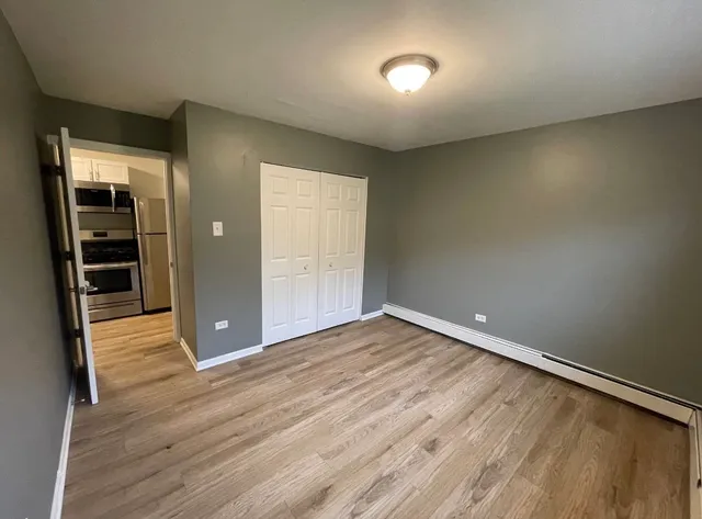 an empty room with wooden floor and closet