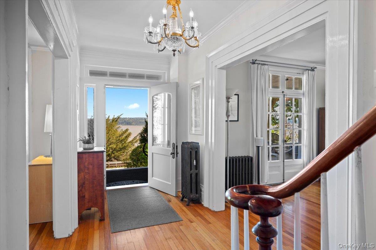 245 River Road Nyack, NY 10960 - Photo 4 of 45 Foyer with light wood-style flooring, radiator heating unit, a chandelier, and ornamental molding