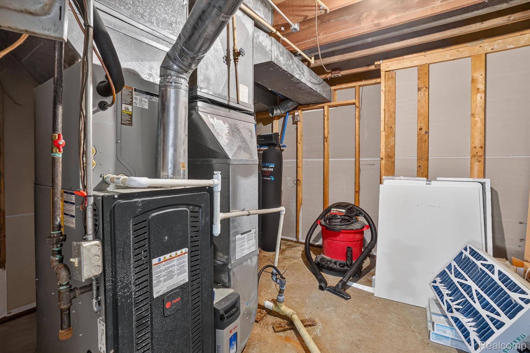 3760 Webberville Road North Williamston, MI 48895 - Photo 36 of 80 Basement mechanical area featuring a furnace unit, exposed overhead ductwork, and a water filtration system
