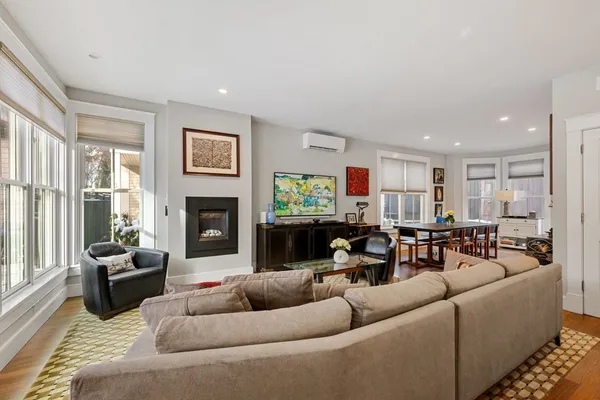 a living room with furniture kitchen view and a fireplace