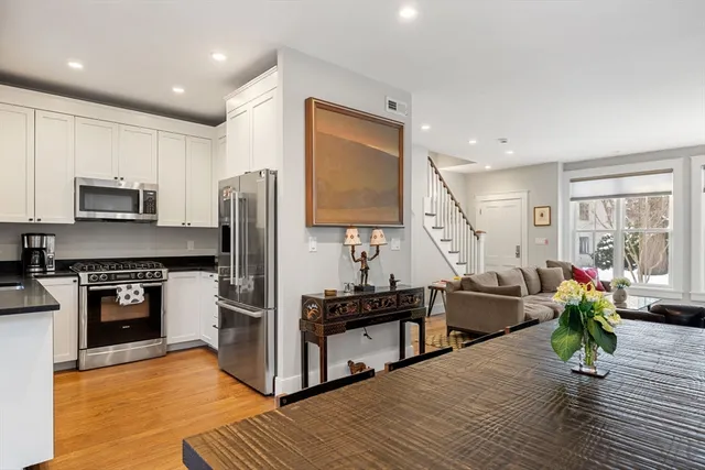 a kitchen with kitchen island a counter top space a sink stainless steel appliances and cabinets