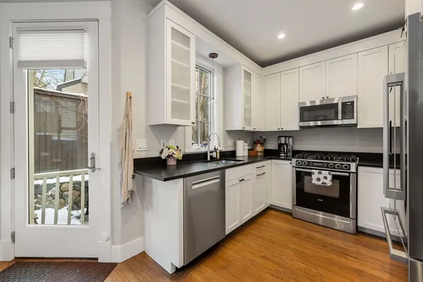 a kitchen with stainless steel appliances granite countertop a stove a sink and a refrigerator