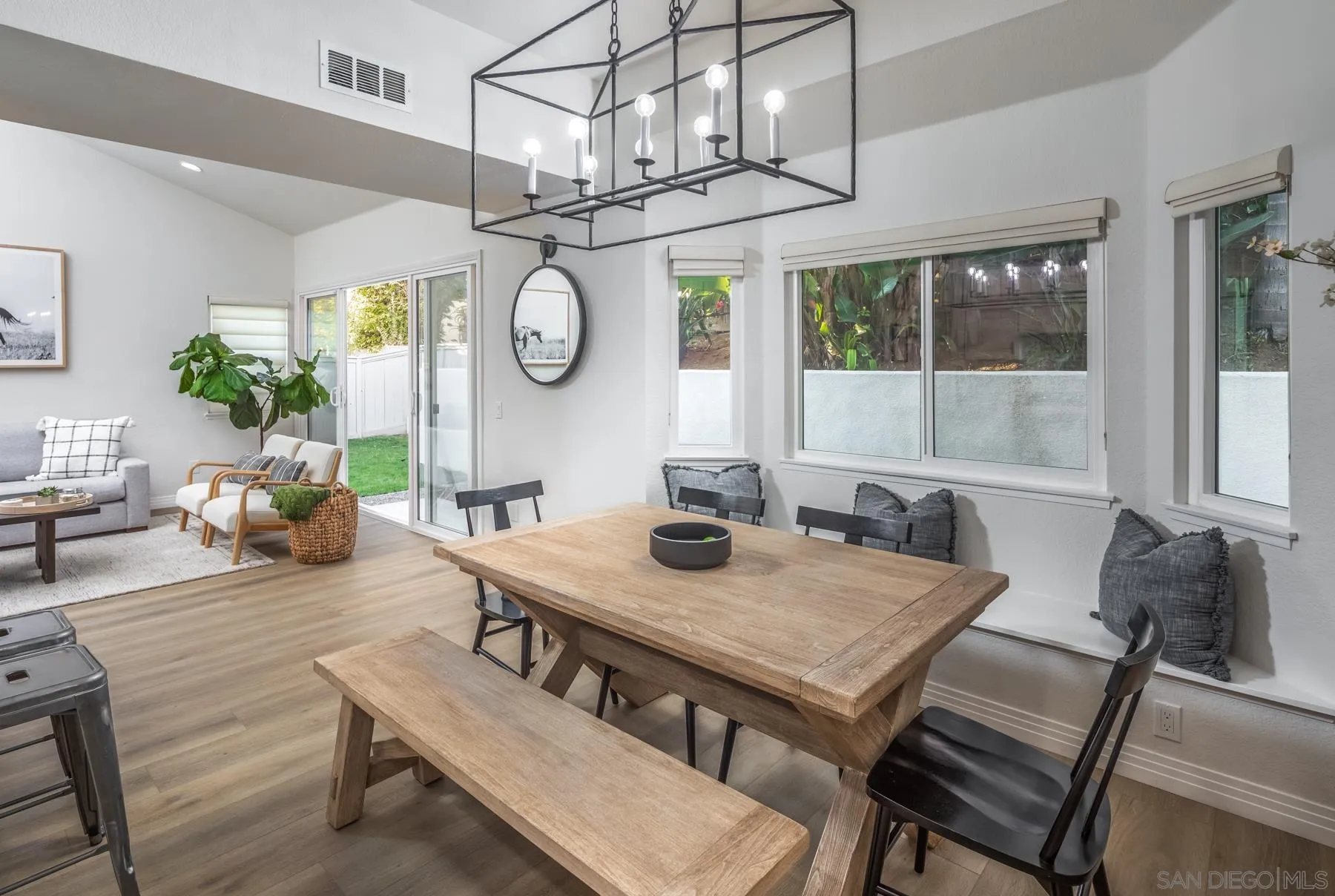 588 Melba Road Encinitas, CA 92024 - Photo 6 of 23 a view of a dining room with furniture a chandelier and wooden floor