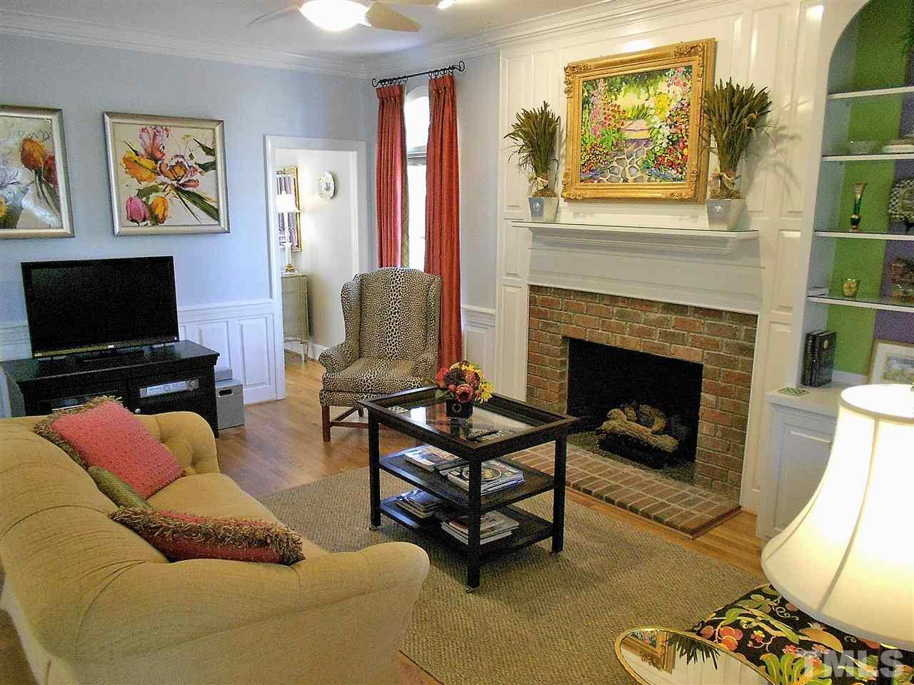 8704 Aldersgate Way Raleigh, NC 27615 - Photo 3 of 25 a living room with furniture a flat screen tv and a fireplace