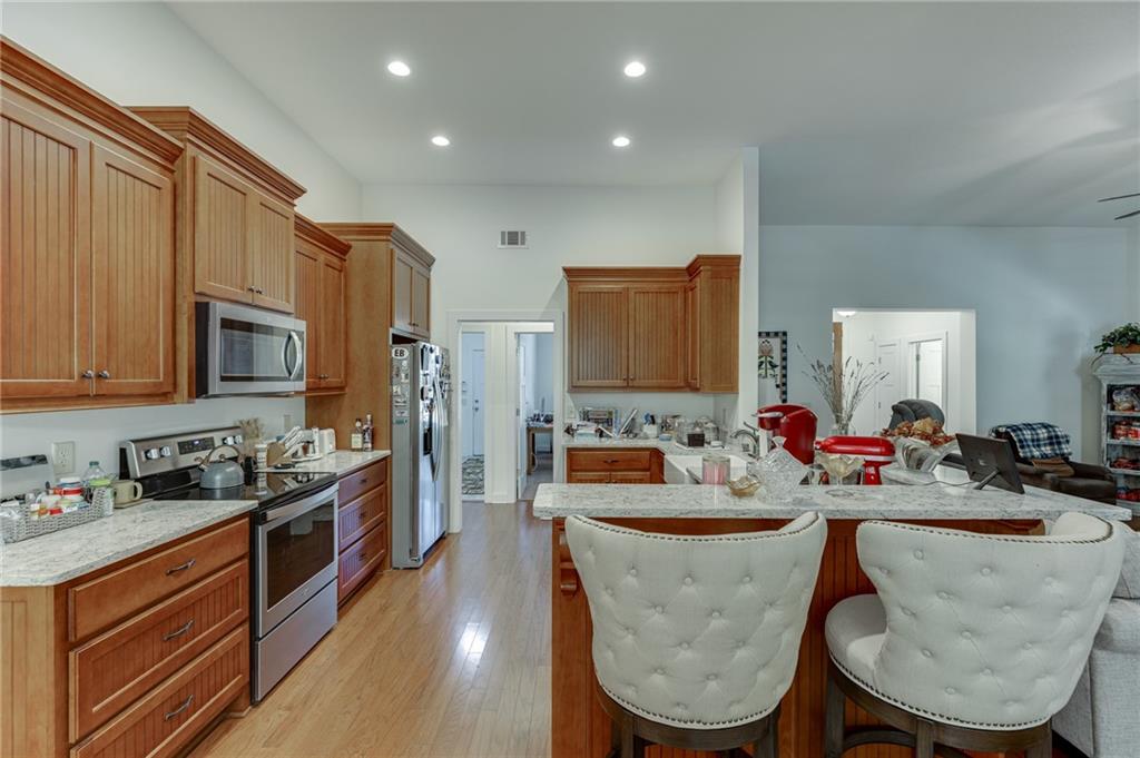 7660 Fern Lane Lula, GA 30554 - Photo 16 of 50 a kitchen with stainless steel appliances granite countertop a sink a stove a refrigerator cabinets and chairs