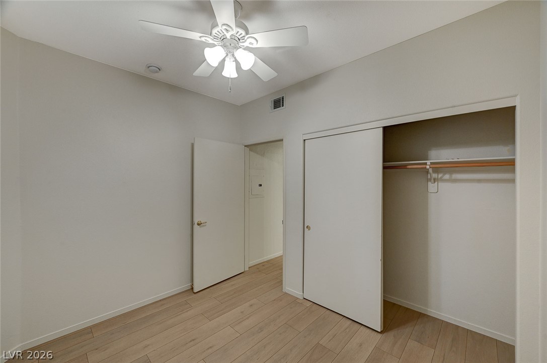 9050 West Warm Springs Road, Unit 1147 Las Vegas, NV 89148 - Photo 32 of 36 Hardwood-style flooring and a functional closet enhance this inviting bedroom space.