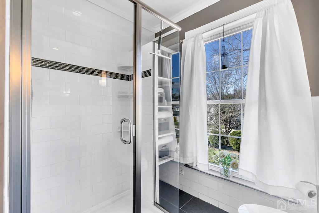 387 Prospect Avenue Dunellen, NJ 08812 - Photo 24 of 34 a bathroom with a glass shower door and a window