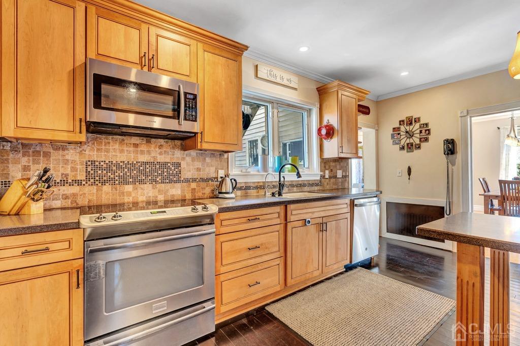 387 Prospect Avenue Dunellen, NJ 08812 - Photo 7 of 34 a kitchen with stainless steel appliances a stove microwave and cabinets