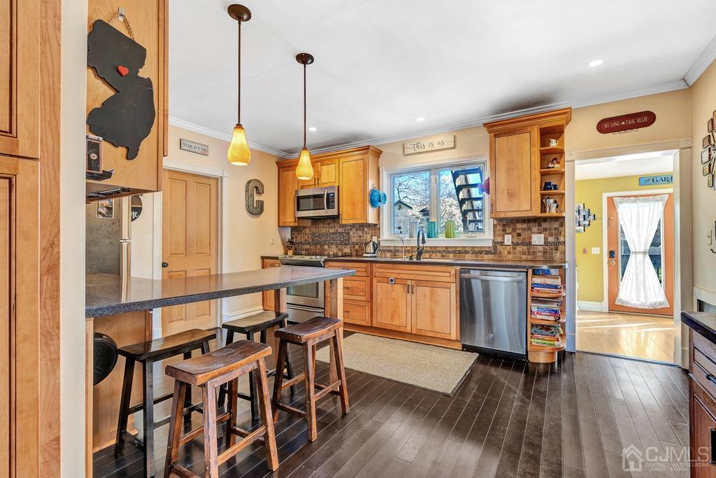 387 Prospect Avenue Dunellen, NJ 08812 - Photo 10 of 34 a kitchen with stainless steel appliances granite countertop wooden floor a dining table and chairs
