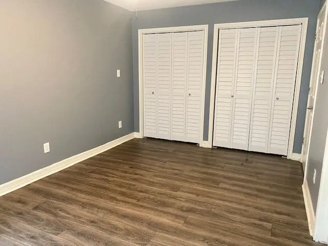an empty room with wooden floor and closet