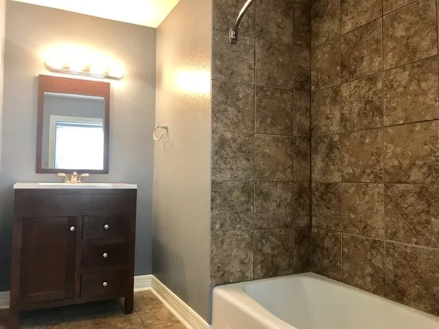 a bathroom with a tub a sink and vanity