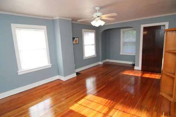 a view of empty room with window and wooden floor