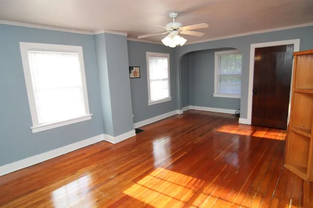 a view of empty room with window and wooden floor