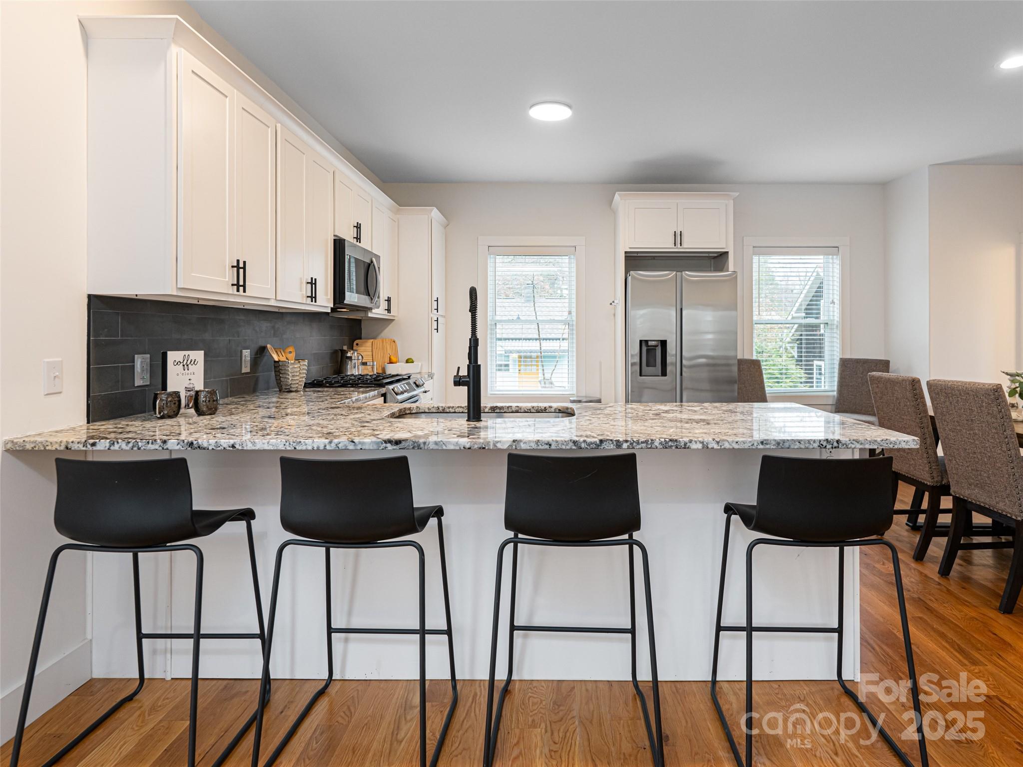 197 Chatham Road Asheville, NC 28804 - Photo 12 of 46 a kitchen with a dining table chairs and white cabinets