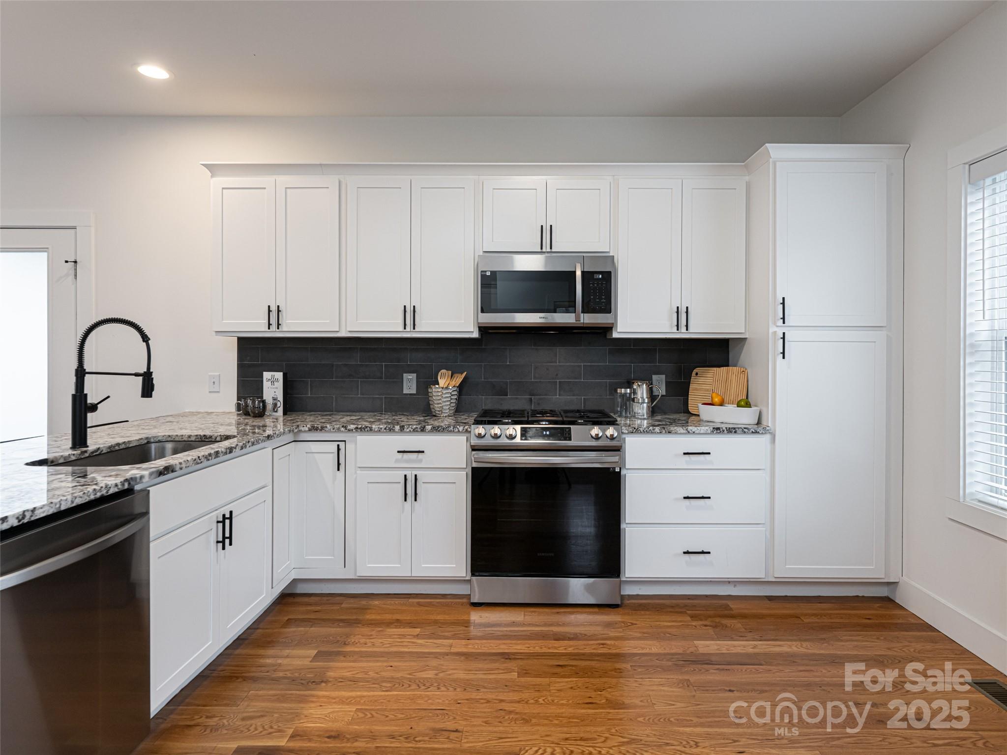 197 Chatham Road Asheville, NC 28804 - Photo 7 of 46 a kitchen with stainless steel appliances granite countertop a stove a sink and a microwave