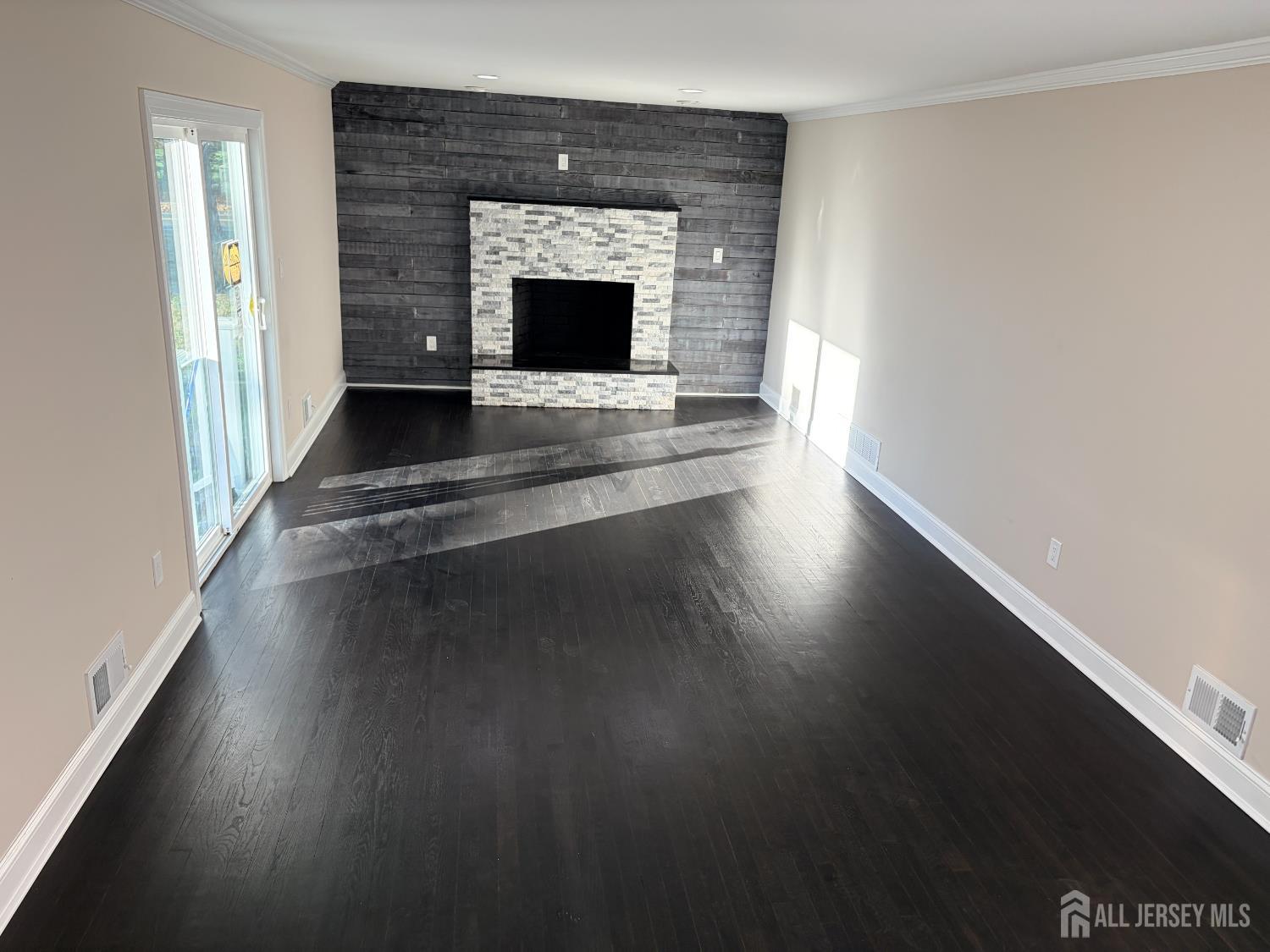 1 Sussex Road East Brunswick, NJ 08816 - Photo 20 of 60 a view of an empty room with wooden floor fire place