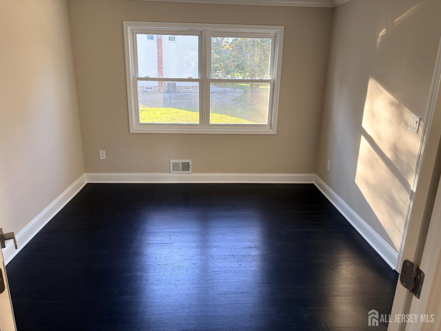 1 Sussex Road East Brunswick, NJ 08816 - Photo 21 of 60 an empty room with wooden floor and windows