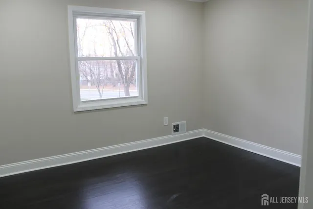 an empty room with wooden floor and closet