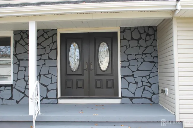 a large kitchen with stainless steel appliances kitchen island granite countertop a refrigerator and a wooden floor