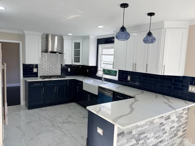 a kitchen with stainless steel appliances kitchen island granite countertop a refrigerator a oven a sink and a stove