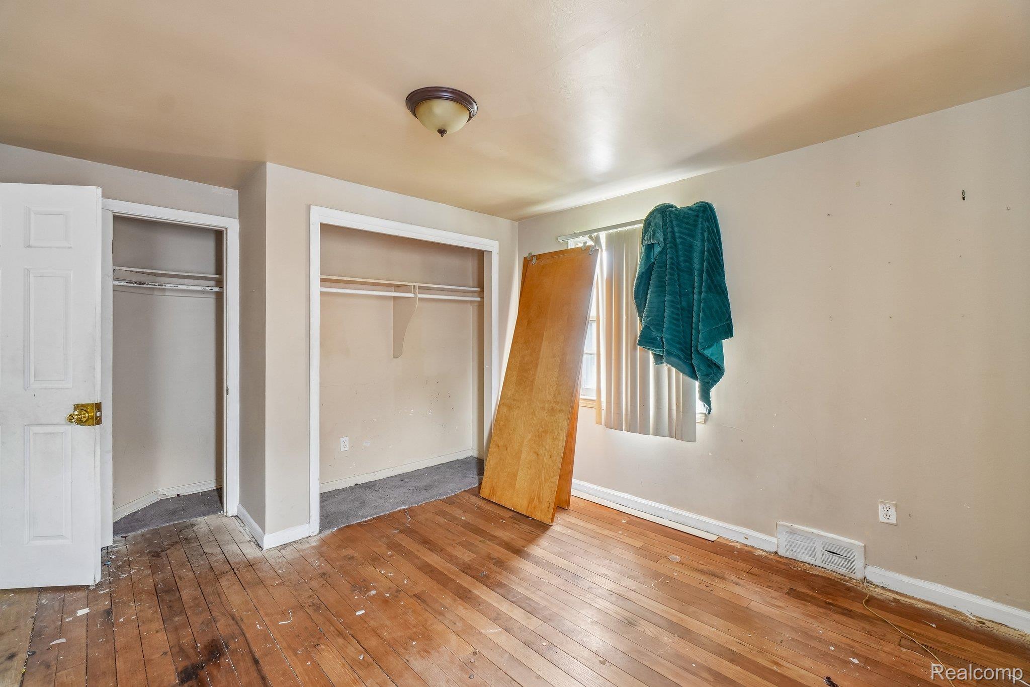 5969 Cadieux Road Detroit, MI 48224 - Photo 15 of 24 Unfurnished bedroom featuring hardwood / wood-style floors and two closets