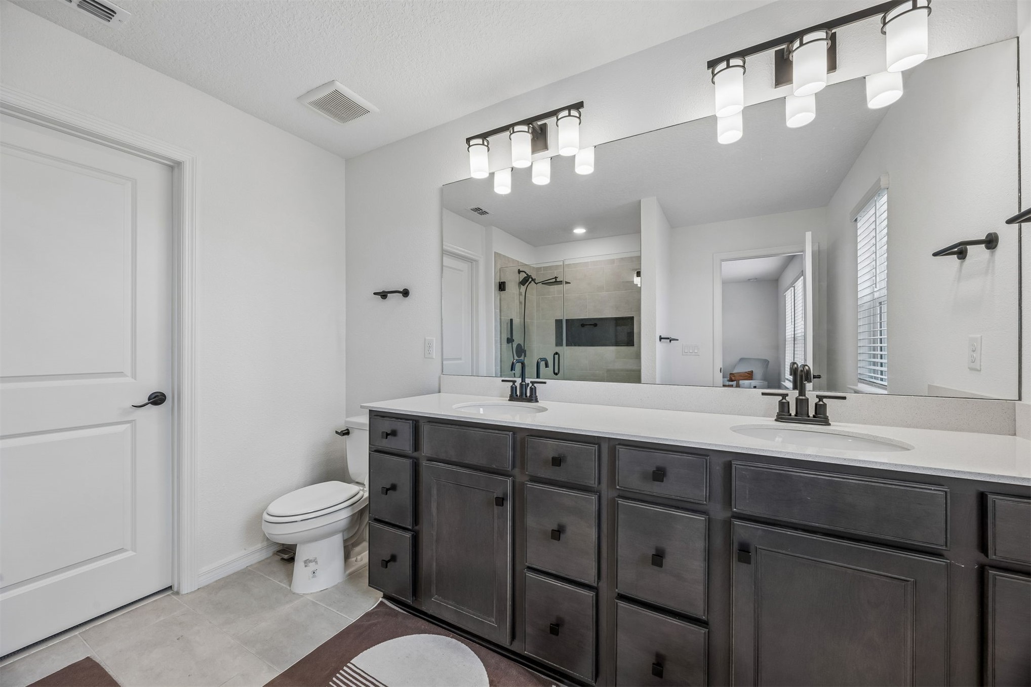 236 Hawthorn Park Circle Yulee, FL 32097 - Photo 16 of 28 a spacious bathroom with a double vanity sink a toilet and a mirror