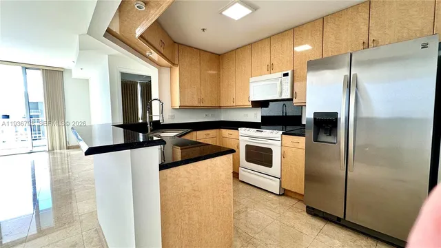 a kitchen with granite countertop a refrigerator and a sink