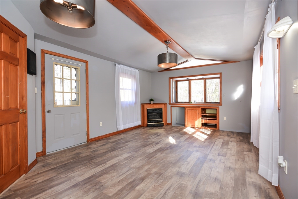 73 Drew Road Derry, NH 03038 - Photo 13 of 42 a view of an empty room with a window and wooden floor