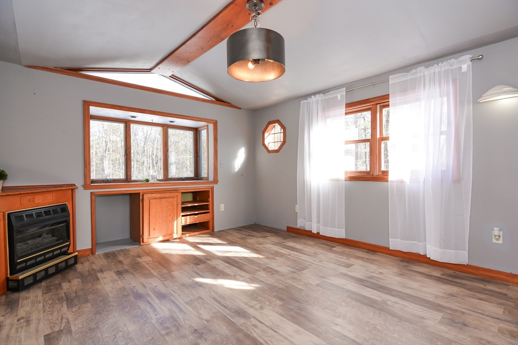 73 Drew Road Derry, NH 03038 - Photo 16 of 42 an empty room with windows cabinet and fireplace