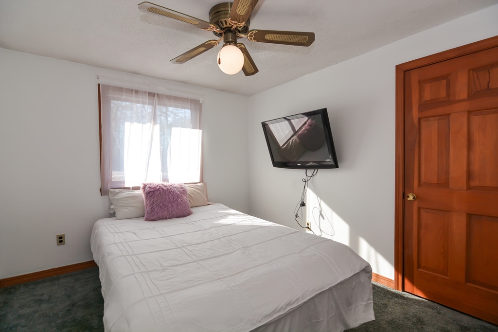 73 Drew Road Derry, NH 03038 - Photo 17 of 42 a bedroom with a bed and a flat screen tv